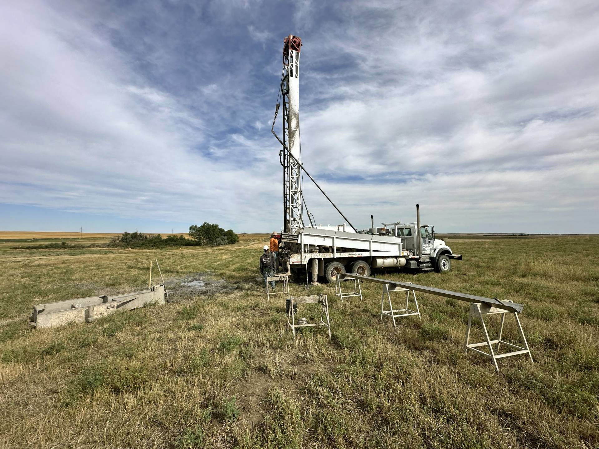 A photo of a drilling truck parked in a field.