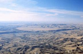 A large terrace is present above the Little Missouri River just east of Bullion Butte in Billings County. The terrace is present near the center of this oblique aerial photograph and is surrounded by badland topography. The sand and gravel capped terrace stands approximately 200 feet above the Little Missouri River and occupies and area of about 3 square miles.(Photo by E. Murphy, NDGS).