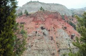 Clinker, the reddish-orange caprock of the hill in the foreground is often used mined for road metal and decorative stone in the southwestern part of the state.(Photo by E. Murphy, NDGS).